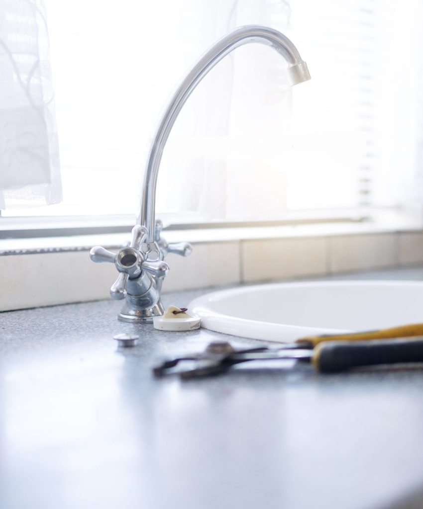 Faucet, tools and plumbing with maintenance in kitchen, repairs on sink with handyman trade and man.
